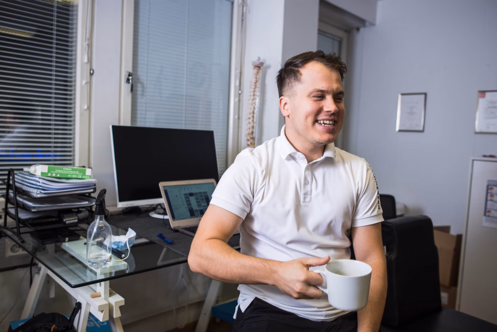 Olli Hakkarainen istuu työpöydän ääressä kahvikuppi kädessä